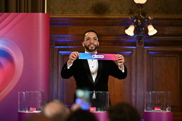 Moderator Austrian singer Cesar Sampson holds a draw for Finland during the draw session for the two semi-final events of the Eurovision Song Contest 2026 on stage at the Vienna’s city hall in Vienna, Austria, on January 12, 2026. Vienna hosts the Eurovision Song Contest 2026 on May 12-14. (Photo by Joe Klamar / AFP)