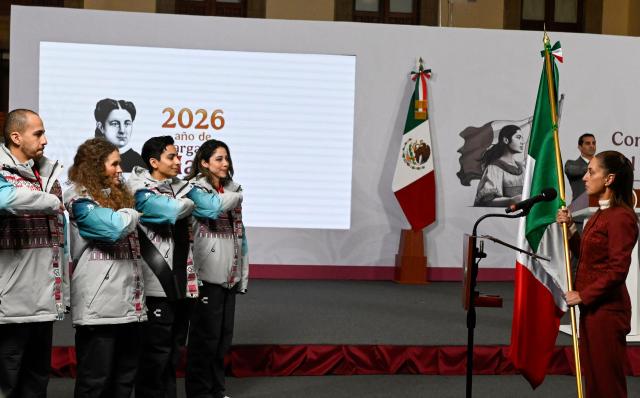 Mexico’s President Claudia Sheinbaum delivers the Mexican flag to Mexican athletes  Allan Corona (L), Sarah Schleper (2nd L), Donovan Carrillo (3nd R) and Regina Martinez (4nd L) that will participate in the Milano-Cortina 2026 Winter Olympic Games, after her daily press conference at the National Palace in Mexico City on January 12, 2026. (Photo by Alfredo ESTRELLA / AFP)