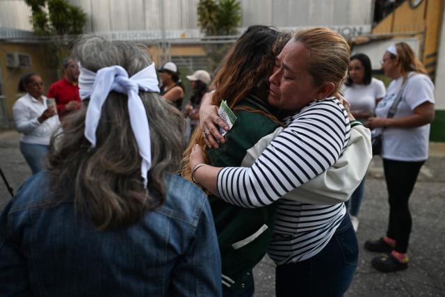 Relatives wait for news on their beloved ones, outside of the Zone 7 of the Bolivarian National Police (PNB) --aka Boleita Detainee Control and Custody Centre-- in Sucre municipality, Metropolitan District of Caracas (DMC) on January 12, 2026. Venezuela said January 12, it had freed dozens more political prisoners as rights groups questioned the numbers and family members clamored for speedier releases after the US military ouster of long-term autocrat Nicolas Maduro. (Photo by Juan BARRETO / AFP)