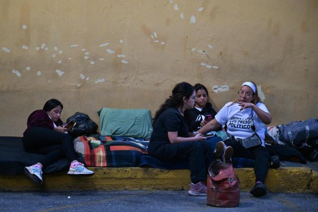 Relatives wait for news on their beloved ones, outside of the Zone 7 of the Bolivarian National Police (PNB) --aka Boleita Detainee Control and Custody Centre-- in Sucre municipality, Metropolitan District of Caracas (DMC) on January 12, 2026. Venezuela said January 12, it had freed dozens more political prisoners as rights groups questioned the numbers and family members clamored for speedier releases after the US military ouster of long-term autocrat Nicolas Maduro. (Photo by Juan BARRETO / AFP)