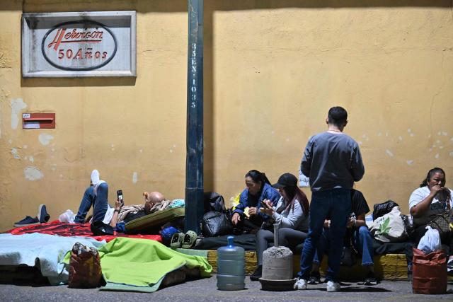 Relatives wait for news on their beloved ones, outside of the Zone 7 of the Bolivarian National Police (PNB) --aka Boleita Detainee Control and Custody Centre-- in Sucre municipality, Metropolitan District of Caracas (DMC) on January 12, 2026. Venezuela said January 12, it had freed dozens more political prisoners as rights groups questioned the numbers and family members clamored for speedier releases after the US military ouster of long-term autocrat Nicolas Maduro. (Photo by Juan BARRETO / AFP)