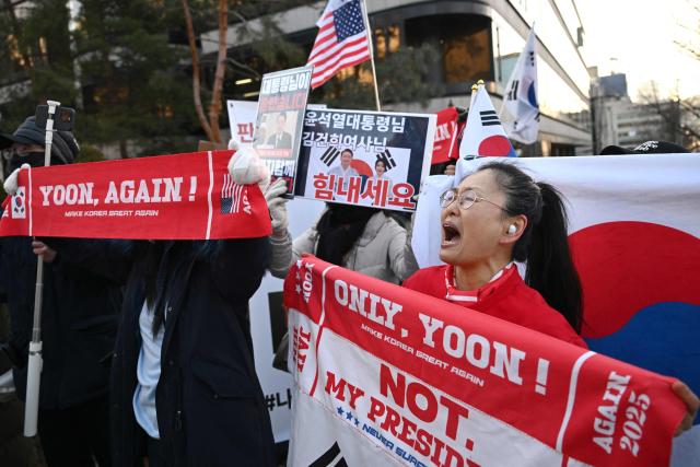 Supporters of South Korea's impeached former president Yoon Suk Yeol gather in front of the Seoul Central District Court in Seoul on January 13, 2026, as Yoon's final criminal trial on insurrection charges is scheduled to be held in the court. (Photo by Jung Yeon-je / AFP)
