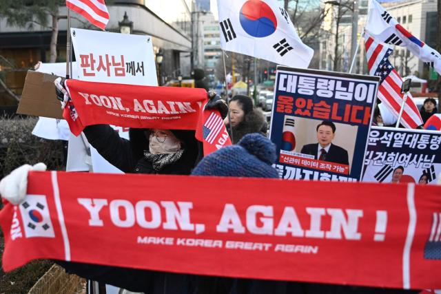Supporters of South Korea's impeached former president Yoon Suk Yeol gather in front of the Seoul Central District Court in Seoul on January 13, 2026, as Yoon's final criminal trial on insurrection charges is scheduled to be held in the court. (Photo by Jung Yeon-je / AFP)