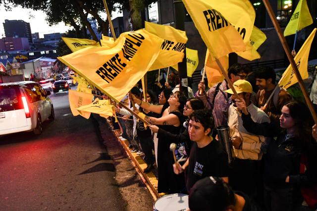 Supporters of Costa Rica's presidential candidate Ariel Robles of the Frente Amplio Party (FA) wave flags of their party during a debate outside the Supreme Electoral Tribunal (TSE) in San Jose, Costa Rica on January 12, 2026. Costa Rica will hold presidential election on February 1. (Photo by EZEQUIEL BECERRA / AFP)