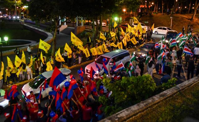 Supporters of Costa Rica's presidential candidates wave flags of their parties during a debate outside the Supreme Electoral Tribunal (TSE) in San Jose, Costa Rica on January 12, 2026. Costa Rica will hold presidential election on February 1. (Photo by EZEQUIEL BECERRA / AFP)