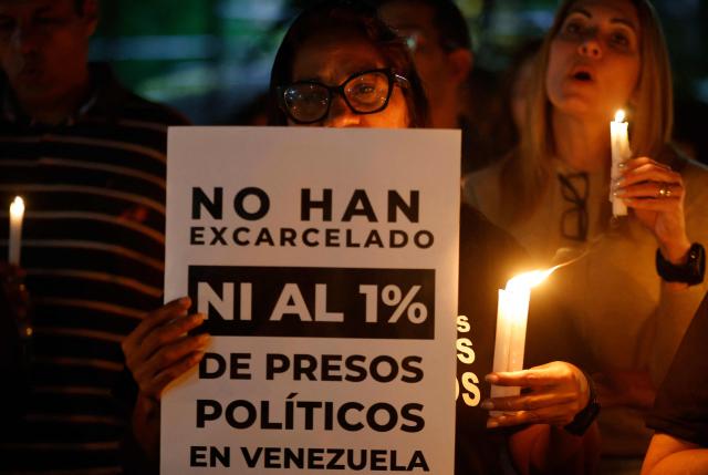 Relatives of political prisoners pray during a candle vigil outside El Rodeo I prison in Guatire, Miranda State, some 30 kilometers east of Caracas on January 12, 2026. Venezuela said January 12, it had freed dozens more political prisoners as rights groups questioned the numbers and family members clamored for speedier releases after the US military ouster of long-term autocrat Nicolas Maduro. (Photo by Pedro MATTEY / AFP)