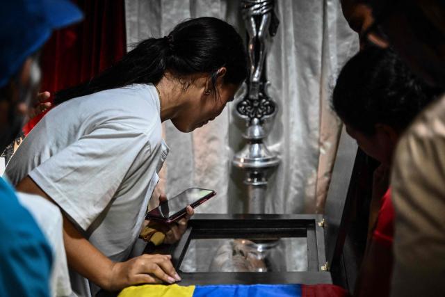 EDITORS NOTE: Graphic content / A woman looks at the coffin of political prisoner Edilson Torres who died in custody, during his funeral in Guanare, Portuguesa state, Venezuela on January 12, 2026. Venezuela said January 12, it had freed dozens more political prisoners as rights groups questioned the numbers and family members clamored for speedier releases after the US military ouster of long-term autocrat Nicolas Maduro. (Photo by Ronaldo SCHEMIDT / AFP)