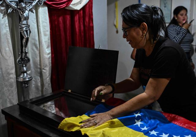 EDITORS NOTE: Graphic content / Emelyn Torres, sister of political prisoners Edilson Torres who died in custody, cries over his coffin during his funeral in Guanare, Portuguesa state, Venezuela on January 12, 2026. Venezuela said January 12, it had freed dozens more political prisoners as rights groups questioned the numbers and family members clamored for speedier releases after the US military ouster of long-term autocrat Nicolas Maduro. (Photo by Ronaldo SCHEMIDT / AFP)