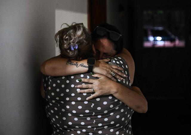 EDITORS NOTE: Graphic content / Relatives of political prisoner Edilson Torres who died in custody, embrace each other during his funeral in Guanare, Portuguesa state, Venezuela on January 12, 2026. Venezuela said January 12, it had freed dozens more political prisoners as rights groups questioned the numbers and family members clamored for speedier releases after the US military ouster of long-term autocrat Nicolas Maduro. (Photo by Ronaldo SCHEMIDT / AFP)