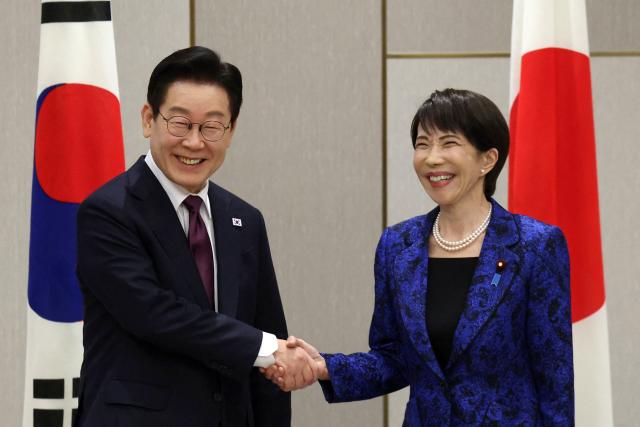 Japan's Prime Minister Sanae Takaichi (R) shakes hands with South Korea's President Lee Jae Myung at the start of their meeting in Nara, Nara Prefecture on January 13, 2026. (Photo by Issei Kato / POOL / AFP)