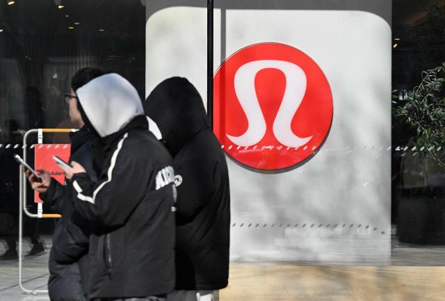 People walk past a Lululemon store, a Canadian brand, in Beijing on January 13, 2026. (Photo by Adek BERRY / AFP)