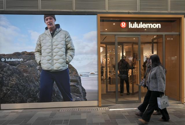 People walk past a Lululemon store, a Canadian brand, in Beijing on January 13, 2026. (Photo by Adek BERRY / AFP)