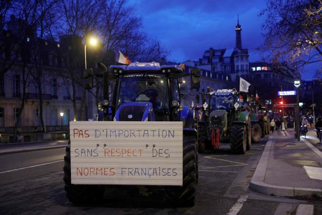 A placard on a tractor reads "no imports without compliance with French standards" as farmers protest to demand "concrete and immediate action" from the government, which is struggling to deal with the anger of farmers in Paris on January 13, 2026. Called by the FNSEA and "Jeunes Agriculteurs" unions and a few days before the signing of the EU-Mercosur agreement, a convoy of farmers entered the capital early in the morning. (Photo by GEOFFROY VAN DER HASSELT / AFP)