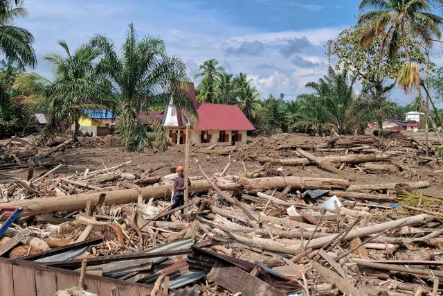 (FILES) The Angkola Protestant Church (background C) is seen amid flood devastation at Aek Ngadol village, South Tapanuli, North Sumatra province, on Christmas Day December 25, 2025, in the aftermath of massive flooding and landslides in the area. Global natural disaster losses dropped sharply to $224 billion in 2025, reinsurer Munich Re said on January 13, 2026, but warned of a still "alarming" picture of extreme weather events driven by climate change. (Photo by AMROE / AFP)
