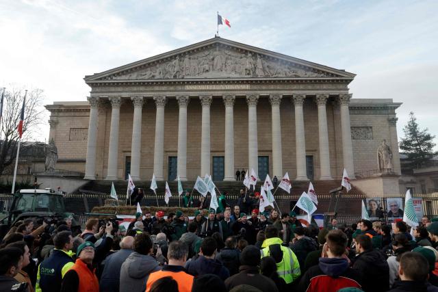 Representatives of French union National Federation of Agricultural Holders' Unions (FNSEA) give speeches as farmers protest in front of the National Assembly  to demand "concrete and immediate action" from the government, which is struggling to deal with the anger of farmers in Paris on January 13, 2026. Called by the FNSEA and "Jeunes Agriculteurs" unions and a few days before the signing of the EU-Mercosur agreement, a convoy of farmers entered the capital early in the morning. (Photo by GEOFFROY VAN DER HASSELT / AFP)