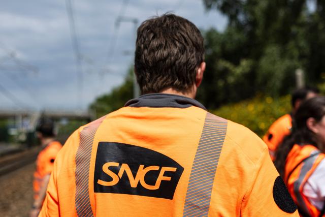(FILES) This photograph shows the logo of French railway company SNCF displayed on a technician's vest as he works to reconnect railway cables at the Mont-de-Terre train station in Lille, northern France on June 25, 2025. Traffic is expected to be almost normal on January 13, 2026 at the SNCF, despite the call for a national strike by two unions on the day when annual wage negotiations within the national railway group are due to be concluded. (Photo by Sameer Al-DOUMY / AFP)