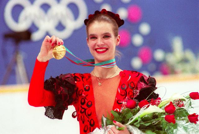 (FILES) East German figure skater Katarina Witt smiles as she displays her gold medal 27 February 1988 at the Olympic Saddledome in Calgary.  Katarina Witt, second behind US rival Debi Thomas after the short program, won the free program event and the overall title to become the first woman figure skater to repeat as Olympic champion (she won the gold medal in Sarajevo in 1984) since Norwegian Sonja Henie (1928, 1932, 1936). (Photo by DANIEL JANIN / AFP)
