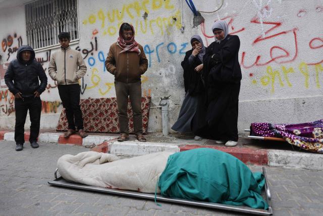 Palestinians mourn over a body during the funeral of three displaced members of the Hamoda family who died after parts of a war-damaged building where they had taken shelter collapsed on a windy winter day in Gaza City on January 13, 2026. A fragile ceasefire has been in place since October, following a deadly war waged by Israel in response to Hamas's unprecedented October 7, 2023 attack on Israel. Nearly 80 percent of buildings in Gaza have been destroyed or damaged by the war, according to UN data. (Photo by Omar AL-QATTAA / AFP)