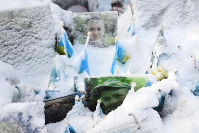 This photograph taken on January 13, 2026 shows portraits of fallen Ukrainian and foreign fighters covered with snow at the memorial on Independence Square in Kyiv, amid the Russian invasion of Ukraine. (Photo by Sergei GAPON / AFP)