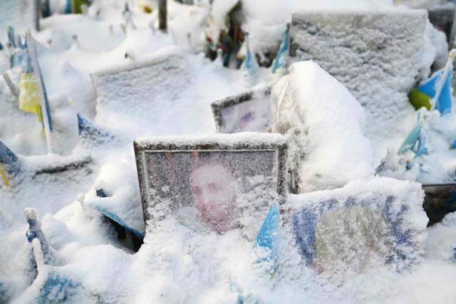 This photograph taken on January 13, 2026 shows portraits of fallen Ukrainian and foreign fighters covered with snow at the memorial on Independence Square in Kyiv, amid the Russian invasion of Ukraine. (Photo by Sergei GAPON / AFP)