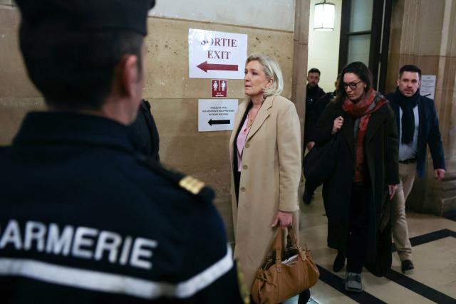 TOPSHOT - President of the parliamentary group of the French far-right Rassemblement National (RN) party, Marine Le Pen arrives for a hearing in her appeal trial on suspicion of embezzlement of European public funds, at Paris courthouse, on January 13, 2026. The appeal comes after a court last year barred Le Pen from running for office for five years over a European Parliament fake-jobs scam involving her and other officials from her National Rally party. The hearing is expected to run until February 12, 2026, with a decision expected this summer. Twelve of the accused, as well as the far-right party itself, have appealed against the verdict while another 12 people -- including one of Le Pen's sisters -- have decided to accept their convictions without appealing. (Photo by Thomas SAMSON / AFP)