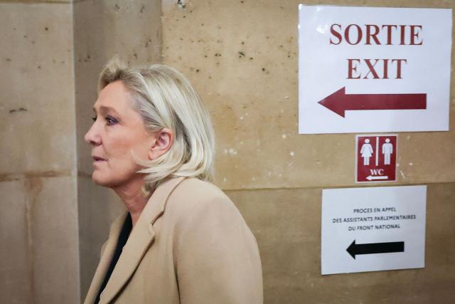 President of the parliamentary group of the French far-right Rassemblement National (RN) party, Marine Le Pen arrives for a hearing in her appeal trial on suspicion of embezzlement of European public funds, at Paris courthouse, on January 13, 2026. The appeal comes after a court last year barred the President of the RN parliamentary group Marine Le Pen from running for office for five years over a European Parliament fake-jobs scam involving her and other officials from her National Rally party. The hearing is expected to run until February 11, 2026, with a decision expected this summer. Twelve of the accused, as well as the far-right party itself, have appealed against the verdict while another 12 people -- including one of Le Pen's sisters -- have decided to accept their convictions without appealing. (Photo by Thomas SAMSON / AFP)