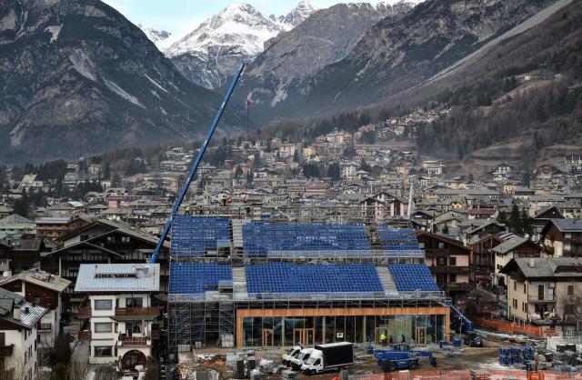 Workers building the main tribune in the finish area in Bormio, which will host all the alpine men's skiing events as part of Milano Cortina 2026 Olympic Games, on January 13, 2026. (Photo by Stefano RELLANDINI / AFP)