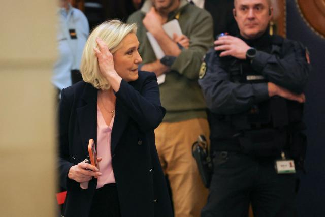 President of the parliamentary group of the French far-right Rassemblement National (RN) party, Marine Le Pen (L) leaves the courtroom on the first day of a hearing in her appeal trial on suspicion of embezzlement of European public funds, at Paris courthouse, on January 13, 2026. The appeal comes after a court last year barred the President of the RN parliamentary group Marine Le Pen from running for office for five years over a European Parliament fake-jobs scam involving her and other officials from her National Rally party. The hearing is expected to run until February 11, 2026, with a decision expected this summer. Twelve of the accused, as well as the far-right party itself, have appealed against the verdict while another 12 people -- including one of Le Pen's sisters -- have decided to accept their convictions without appealing. (Photo by Thomas SAMSON / AFP)