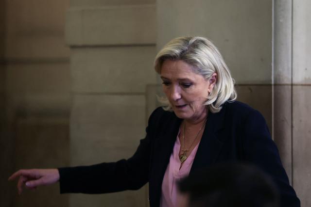 President of the parliamentary group of the French far-right Rassemblement National (RN) party, Marine Le Pen leaves the courtroom during a pause on the first day of a hearing in her appeal trial on suspicion of embezzlement of European public funds, at Paris courthouse, on January 13, 2026. The appeal comes after a court last year barred the President of the RN parliamentary group Marine Le Pen from running for office for five years over a European Parliament fake-jobs scam involving her and other officials from her National Rally party. The hearing is expected to run until February 11, 2026, with a decision expected this summer. Twelve of the accused, as well as the far-right party itself, have appealed against the verdict while another 12 people -- including one of Le Pen's sisters -- have decided to accept their convictions without appealing. (Photo by Alain JOCARD / AFP)