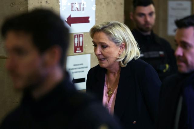 President of the parliamentary group of the French far-right Rassemblement National (RN) party, Marine Le Pen leaves the courtroom during a pause on the first day of a hearing in her appeal trial on suspicion of embezzlement of European public funds, at Paris courthouse, on January 13, 2026. The appeal comes after a court last year barred the President of the RN parliamentary group Marine Le Pen from running for office for five years over a European Parliament fake-jobs scam involving her and other officials from her National Rally party. The hearing is expected to run until February 11, 2026, with a decision expected this summer. Twelve of the accused, as well as the far-right party itself, have appealed against the verdict while another 12 people -- including one of Le Pen's sisters -- have decided to accept their convictions without appealing. (Photo by Alain JOCARD / AFP)