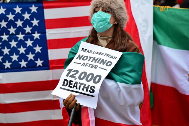 An anti-Iranian regime protester holds a placard during a rally outside the US Consulate in Milan on January 13, 2026. (Photo by Piero CRUCIATTI / AFP)