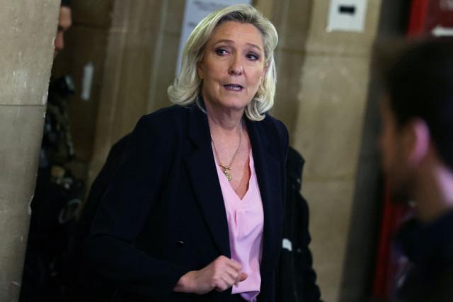 President of the parliamentary group of the French far-right Rassemblement National (RN) party, Marine Le Pen leaves the courtroom during a pause on the first day of a hearing in her appeal trial on suspicion of embezzlement of European public funds, at Paris courthouse, on January 13, 2026. The appeal comes after a court last year barred the President of the RN parliamentary group Marine Le Pen from running for office for five years over a European Parliament fake-jobs scam involving her and other officials from her National Rally party. The hearing is expected to run until February 11, 2026, with a decision expected this summer. Twelve of the accused, as well as the far-right party itself, have appealed against the verdict while another 12 people -- including one of Le Pen's sisters -- have decided to accept their convictions without appealing. (Photo by Alain JOCARD / AFP)