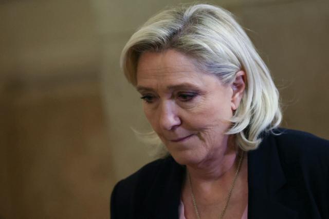 President of the parliamentary group of the French far-right Rassemblement National (RN) party, Marine Le Pen leaves the courtroom during a pause on the first day of a hearing in her appeal trial on suspicion of embezzlement of European public funds, at Paris courthouse, on January 13, 2026. The appeal comes after a court last year barred the President of the RN parliamentary group Marine Le Pen from running for office for five years over a European Parliament fake-jobs scam involving her and other officials from her National Rally party. The hearing is expected to run until February 11, 2026, with a decision expected this summer. Twelve of the accused, as well as the far-right party itself, have appealed against the verdict while another 12 people -- including one of Le Pen's sisters -- have decided to accept their convictions without appealing. (Photo by Alain JOCARD / AFP)