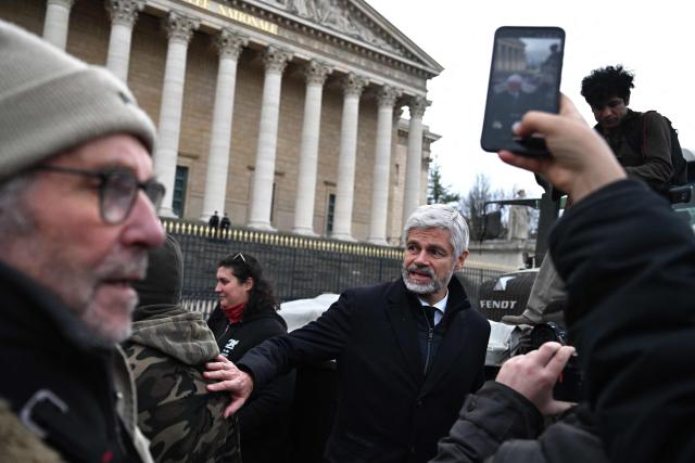 President of Droite Republicaine parliamentary group Laurent Wauquiez (C) meets farmers protesting in front of the National Assembly to demand "concrete and immediate action" from the government, in Paris on January 13, 2026. Called by the French union National Federation of Agricultural Holders' Unions (FNSEA) and "Jeunes Agriculteurs" union and a few days before the signing of the EU-Mercosur agreement, a convoy of farmers entered the capital early in the morning. (Photo by Martin LELIEVRE / AFP)