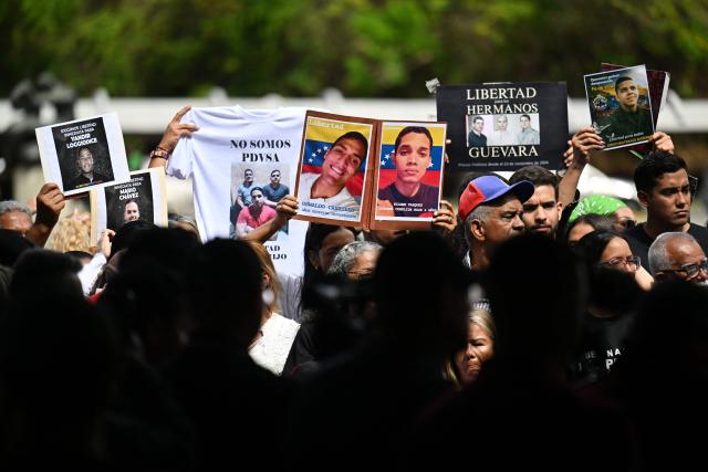 Relatives hold portraits of political prisoners during a demonstration by relatives at the Central University of Venezuela in Caracas on January 13, 2026. Venezuela said on January 12, it had freed dozens more political prisoners as rights groups questioned the numbers and family members clamored for speedier releases after the US military ouster of long-term autocrat Nicolas Maduro. (Photo by Juan BARRETO / AFP)
