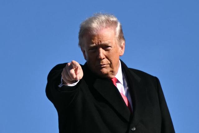 US President Donald Trump gestures as he boards Air Force One at Joint Base Andrews, Maryland on January 13, 2026, as he travels to Detroit, Michigan. (Photo by Mandel NGAN / AFP)