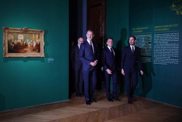 French President Emmanuel Macron (C) and King Felipe VI of Spain (L) visit the exhibition "The Grand Dauphin (1661-1711), son of a King, father of a King, and never King" at the Chateau de Versailles in Versailles, near Paris, on January 13, 2026. (Photo by Gonzalo Fuentes / POOL / AFP)