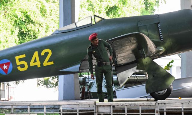 A guard stands in front of an airplane at the Revolution Museum, which is dedicated to preserving the history and legacy of the Cuban Revolution, in Havana on January 13, 2026. (Photo by YAMIL LAGE / AFP)