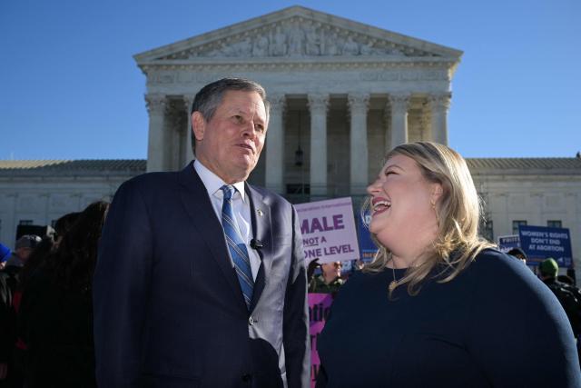 (L/R) US Senator Steve Daines, Republican from Montana, speaks with US Representative Kat Cammack, Republican from Florida, speak with each other outside the US Supreme Court as justices hear arguments in challenges to state bans on transgender girls and women in sports, in Washington, DC, on January 13, 2026. The US Supreme Court on January 13 wades into the hot-button issue of transgender athletes in girls' and women's sports. The conservative-dominated court is to hear challenges to state laws in Idaho and West Virginia banning transgender athletes from female competition. More than two dozen US states have passed laws in recent years barring athletes who were assigned as male at birth from taking part in girls' or women's sports. (Photo by Oliver Contreras / AFP)