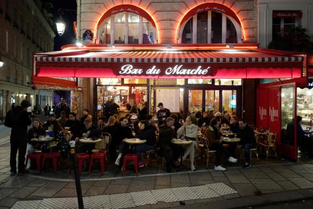 Customers have drinks on the terrace of Bar du Marche bar in central Paris on December 16, 2025. France's President argued on January 5, 2026 for the inclusion of French bistros and cafes in UNESCO's intangible cultural heritage, alongside the baguette. The French Bistros and Cafes Association launched an initiative in 2024 to have these convivial places listed as UNESCO World Heritage sites. "The bistros and cafes of France are keepers of time. They cross centuries and intersect generations," it emphasizes on its website. (Photo by Ludovic MARIN / AFP)