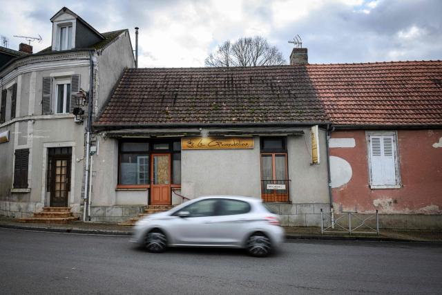 A car drives past the closed Le Gwendoline bar in Allogny, central France, on January 8, 2026. France's President argued on January 5, 2026 for the inclusion of French bistros and cafes in UNESCO's intangible cultural heritage, alongside the baguette. The French Bistros and Cafes Association launched an initiative in 2024 to have these convivial places listed as UNESCO World Heritage sites. "The bistros and cafes of France are keepers of time. They cross centuries and intersect generations," it emphasizes on its website. (Photo by Loic VENANCE / AFP)