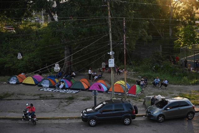 Relatives of inmates camp while waiting for news about the release of prisoners outside El Rodeo I prison in Guatire, Miranda State, some 30 kilometers east of Caracas on January 13, 2026. Venezuela said on January 12, it had freed dozens more political prisoners as rights groups questioned the numbers and family members clamored for speedier releases after the US military ouster of long-term autocrat Nicolas Maduro. (Photo by Federico PARRA / AFP)