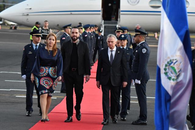 Costa Rica's Vice President Mary Munive (L) and Costa Rica's Foreign Minister Andre Tinoco (R) welcome El Salvador's President Nayib Bukele upon his arrival at Juan Santa Maria International Airport in Alajuela, Costa Rica, on January 13, 2026. (Photo by EZEQUIEL BECERRA / AFP)