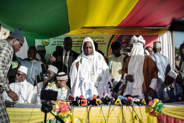 (FILES) Malian influential imam Mahmoud Dicko (C) stands during a public meeting in a rare public appearance in Bamako on November 28, 2021. With Malian Imam in exile Mahmoud Dicko's new movement, the Coalition of Forces for the Republic (CFR), this key figure in Mali, at the crossroads of religion and politics, aims to re-establish dialogue between the various parties and overthrow the military, which has been in power since a double coup in 2020 and 2021. (Photo by FLORENT VERGNES / AFP)