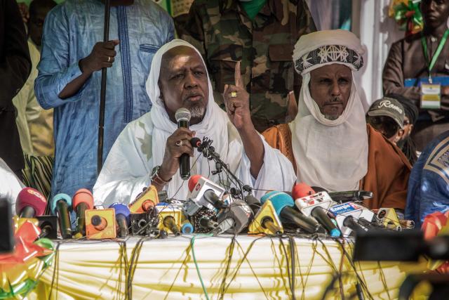 (FILES) Malian influential imam Mahmoud Dicko (L) speaks during a public meeting in a rare public appearance in Bamako on November 28, 2021. With Malian Imam in exile Mahmoud Dicko's new movement, the Coalition of Forces for the Republic (CFR), this key figure in Mali, at the crossroads of religion and politics, aims to re-establish dialogue between the various parties and overthrow the military, which has been in power since a double coup in 2020 and 2021. (Photo by FLORENT VERGNES / AFP)