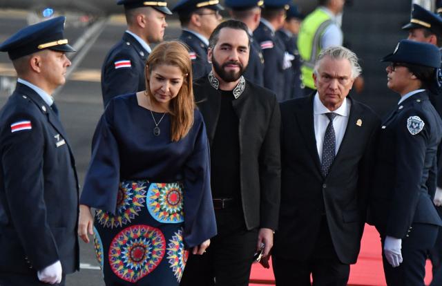 Costa Rica's Vice President Mary Munive (L) and Costa Rica's Foreign Minister Andre Tinoco (R) welcome El Salvador's President Nayib Bukele upon his arrival at Juan Santa Maria International Airport in Alajuela, Costa Rica, on January 13, 2026. (Photo by EZEQUIEL BECERRA / AFP)