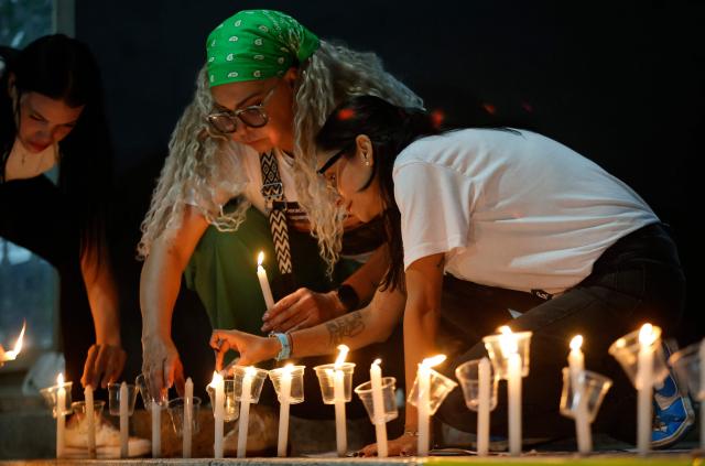 Women lit candles during a vigil to demand freedom for political prisoners at El Helicoide -a facility and prison owned by the Venezuelan government and used for both regular and political prisoners of the Bolivarian National Intelligence Service (SEBIN)- in Caracas on January 13, 2026. Venezuela said on January 12, it had freed dozens more political prisoners as rights groups questioned the numbers and family members clamored for speedier releases after the US military ouster of long-term autocrat Nicolas Maduro. (Photo by Pedro MATTEY / AFP)