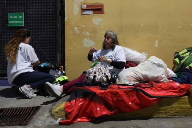 A drinks water during a vigil to demand freedom for political prisoners at El Helicoide -a facility and prison owned by the Venezuelan government and used for both regular and political prisoners of the Bolivarian National Intelligence Service (SEBIN)- in Caracas on January 13, 2026. Venezuela said on January 12, it had freed dozens more political prisoners as rights groups questioned the numbers and family members clamored for speedier releases after the US military ouster of long-term autocrat Nicolas Maduro. (Photo by Pedro MATTEY / AFP)