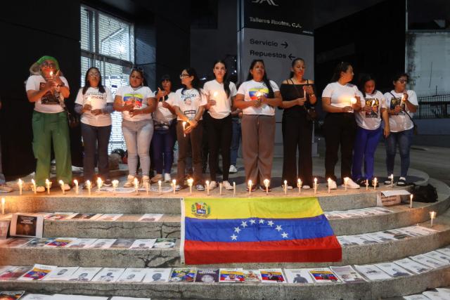 People attend a vigil to demand freedom for political prisoners at El Helicoide -a facility and prison owned by the Venezuelan government and used for both regular and political prisoners of the Bolivarian National Intelligence Service (SEBIN)- in Caracas on January 13, 2026. Venezuela said on January 12, it had freed dozens more political prisoners as rights groups questioned the numbers and family members clamored for speedier releases after the US military ouster of long-term autocrat Nicolas Maduro. (Photo by Pedro MATTEY / AFP)