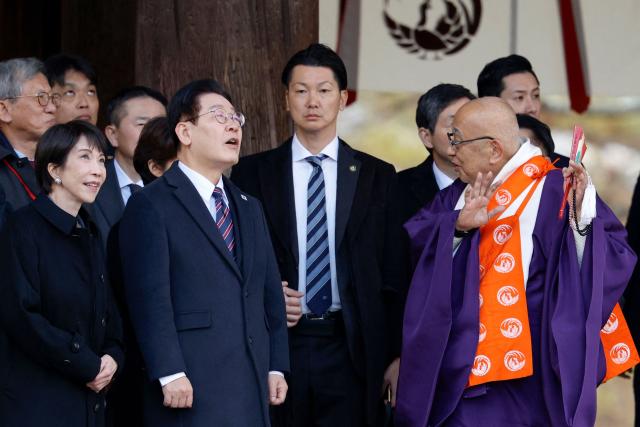 Japan'sPrime Minister Sanae Takaichi (L) and South Korea's President Lee Jae Myung (2nd L) listen to explanations from head priest Shokaku Furuya (R) as they visit the Western Precinct (Saiin Garan) at the Horyu-ji Temple in Ikaruga, Nara prefecture on January 14, 2026. (Photo by Franck ROBICHON / POOL / AFP)